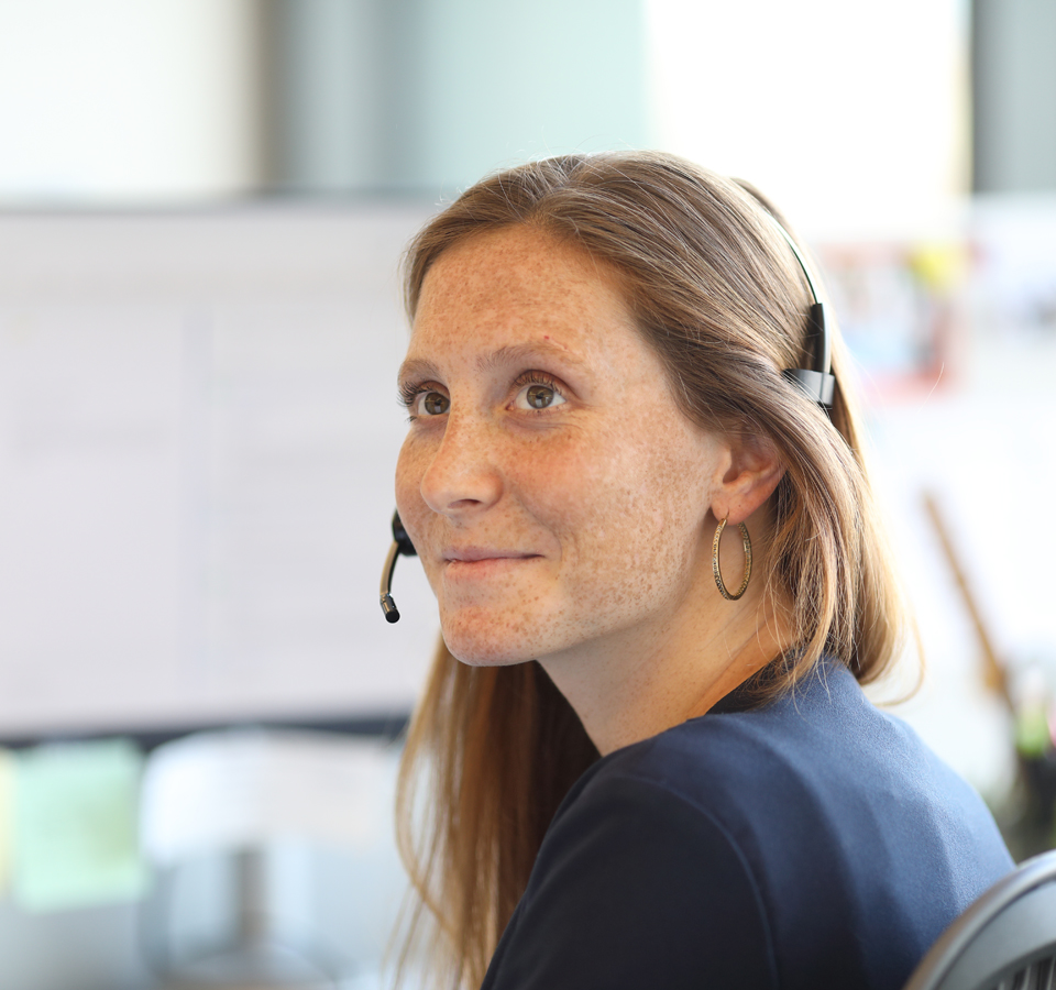 Close-up of a woman sitting in a chair with a headset on.
